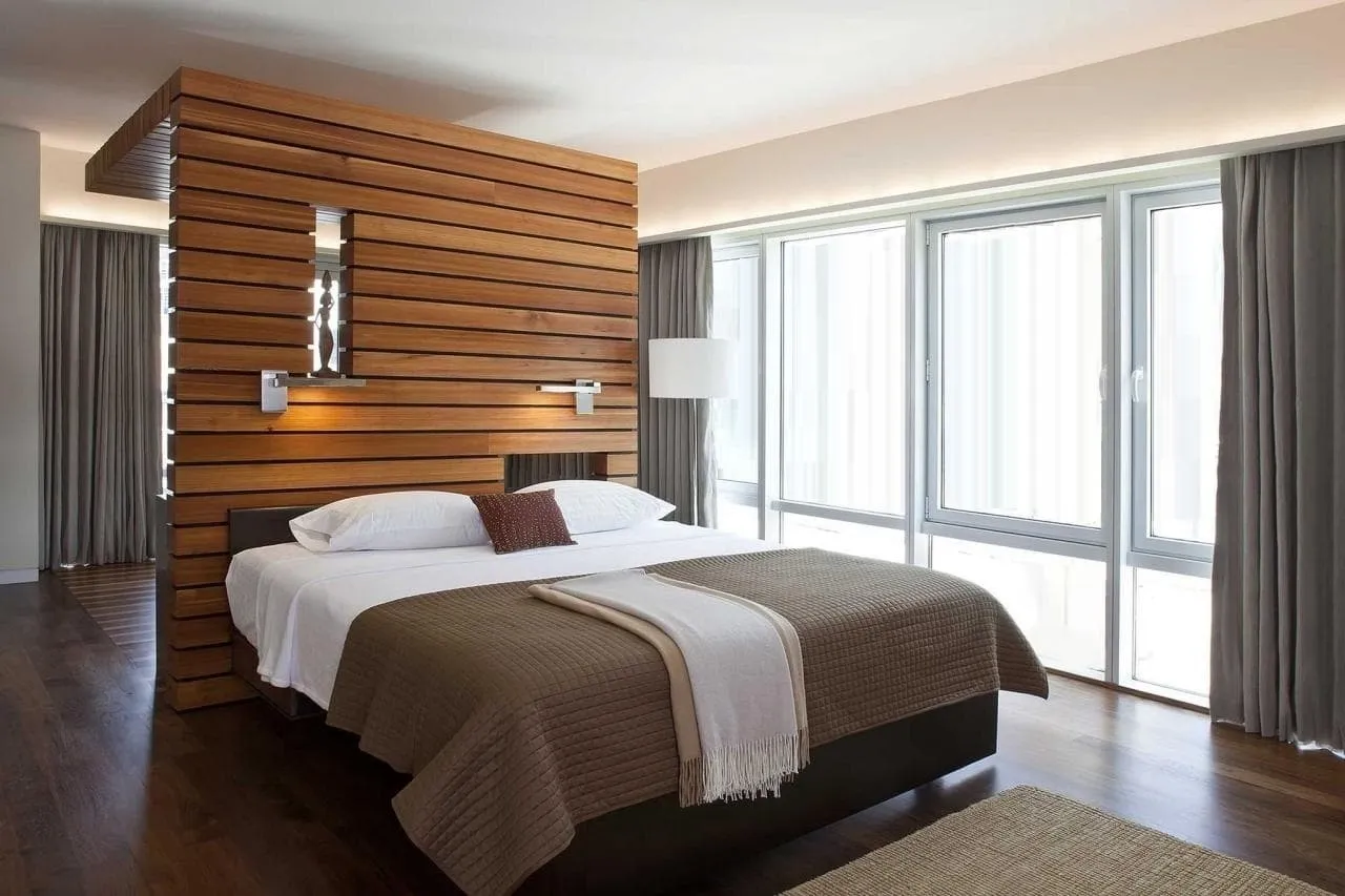 Стильное конструкция из дерева выполняющее двойную функцию: зонирование помещения и изголовье кровати