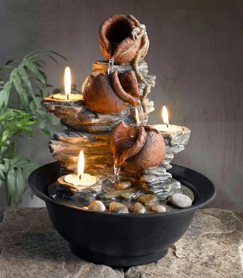 Декоративный каменный фонтан со свечами