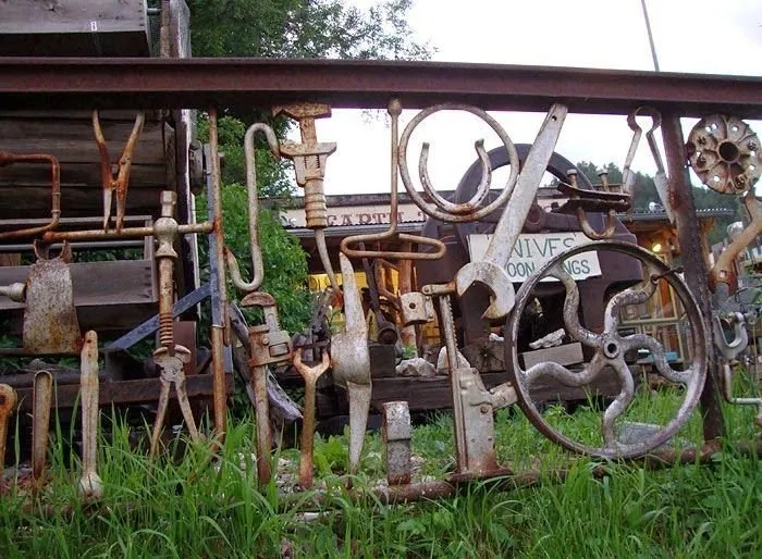 настоящий забор ремесленника — колеса, крюки, гаечные ключи и тиски украшают конструкцию